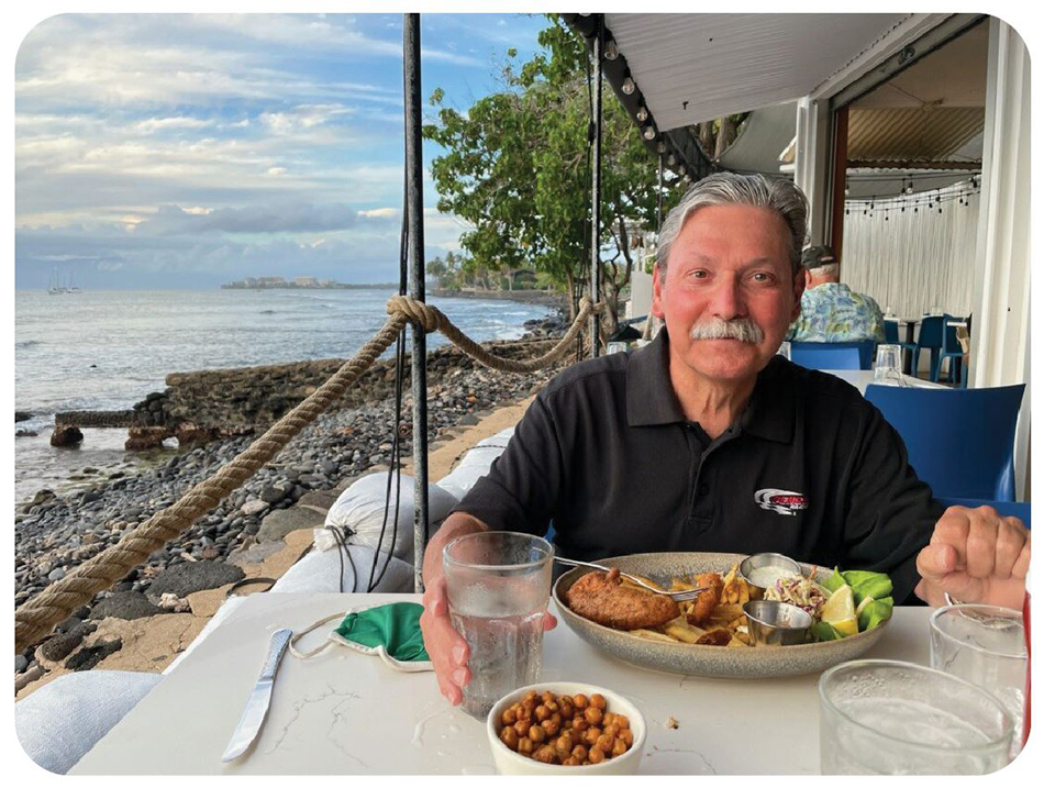 Judge Shively from across the table, fish dinner in front of him, and the Maui coastline extending into the distance.