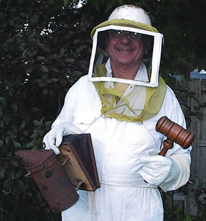 Judge Thomas Milligan in his beekeeper suit tending to his apiary.