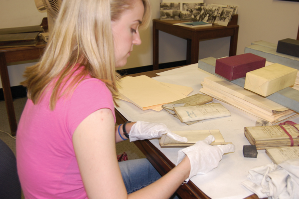 Photo: A volunteer sorts through historic case documents