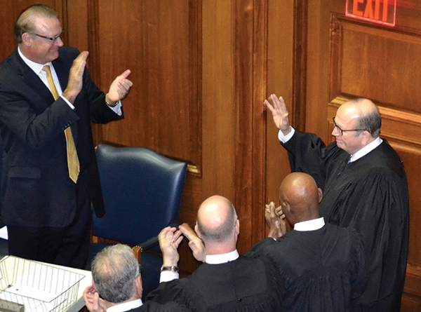 Justice Brent Dickson waves as he is applauded by his colleagues and attendees of the 2016 State of the Judiciary, in January.