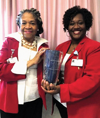 Program manager, Vanessa Nathan (left) and program coordinator LaVonne Jarrett hold the ‘Program of Excellence’ award.