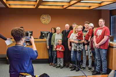 enior Judge Gerald Zore and a family are photographed following an adoption proceeding in Marion County.