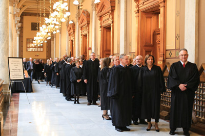 Indiana trial court judges stand in the hallway of the State House as they wait to enter the gallery of the Indiana House of Representatives.