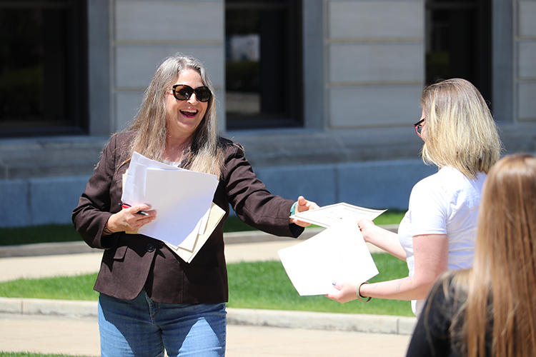 Allen County Judge Frances Gull smiles as she hands out a certificate at an outdoor Problem-Solving Court celebration.