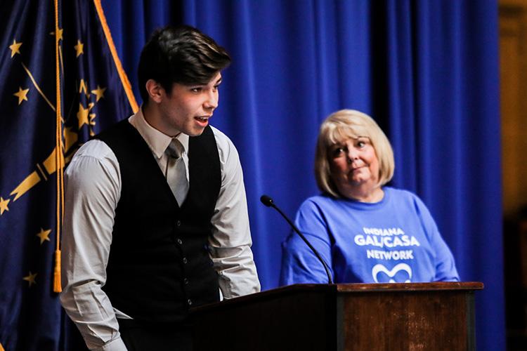 Kenneth stands behind a podium alongside his CASA, Linda Brown, during CASA Day at the Indiana State House.