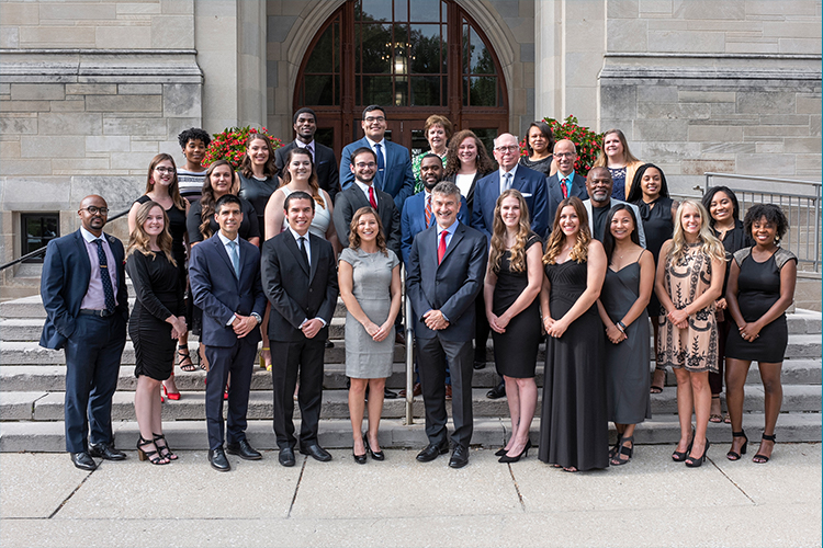 A large group of people gather on a set of stairs for a photo.