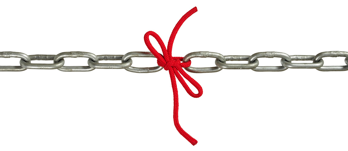 Two metal chains with a red cord tied in a bow connecting them together