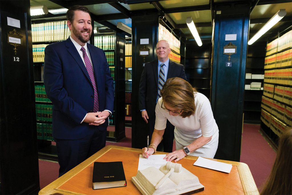 Chief Justice Rush signs Justice Molter's September 1 written oath of office as appellate Clerk Greg Pachmayr waits to officially file it in the Clerk's Office.