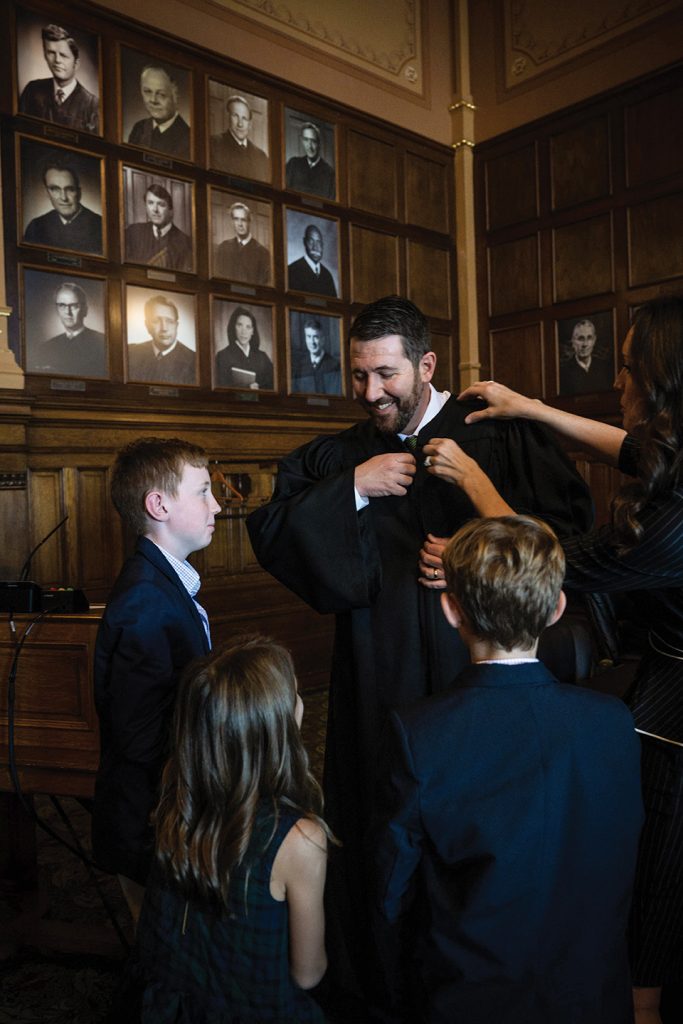 Justice Molter's wife Katie and children help him into his new judge's robe before he joins the rest of the Court on the bench.