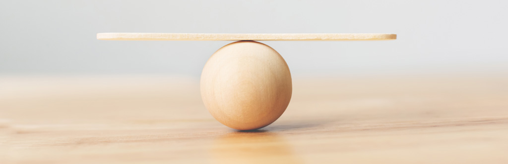 Small wooden board balanced on a wooden sphere.