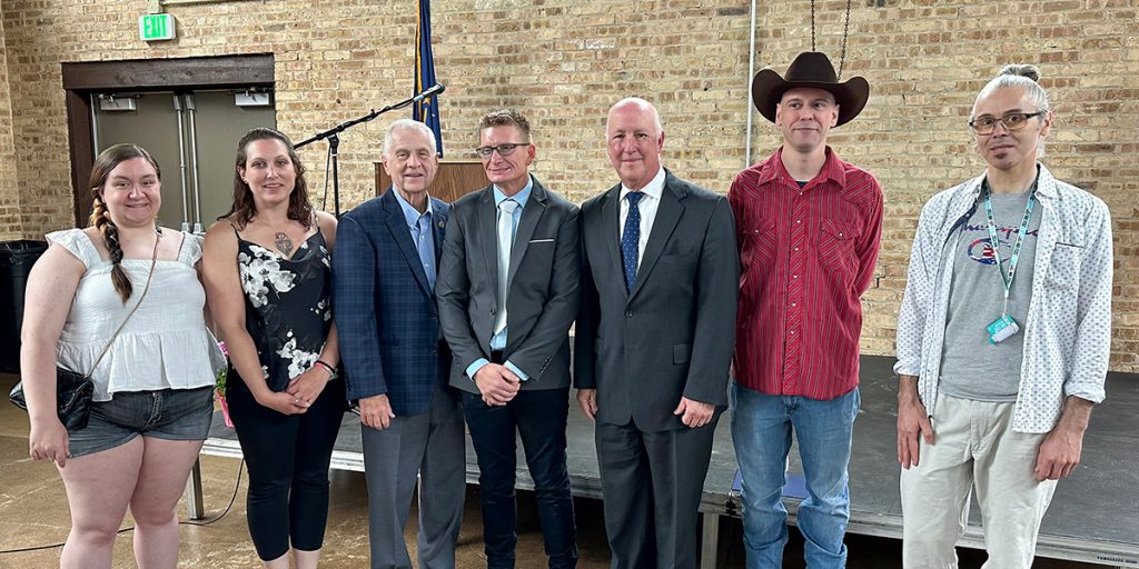 Group photo of Justice Mark Massa stands with graduates celebrating 18-months of sobriety.