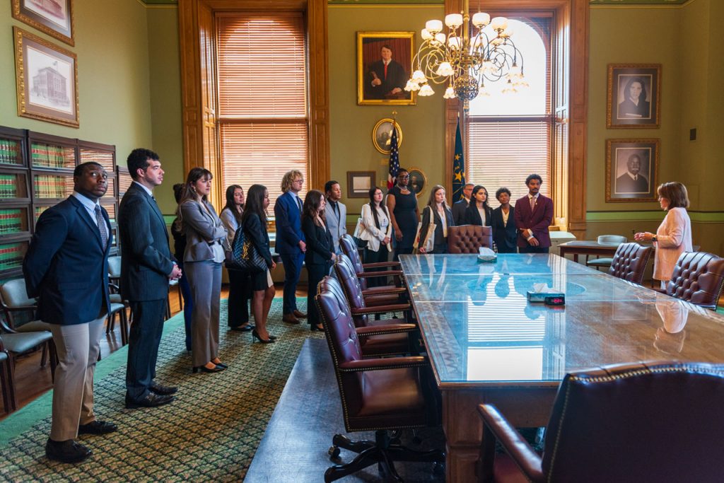 Chief Justice Loretta Rush talks with the 16 2024 ICLEO fellows in the supreme court conference room.