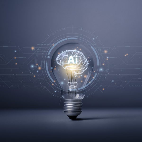 Abstract composition of a lightbulb powering a brain with the letters "AI" imprinted over it.