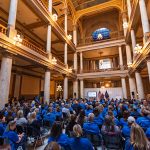 Volunteers wearing blue shits fill the Statehouse atrium to hear from various speakers on CASA day.