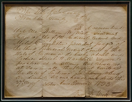 A framed handwritten document on unfolded, aged paper.