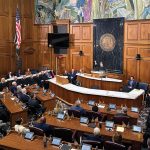 Chief Justice Loretta Rush at the podium in the House Chamber raising a hand to honor a special guest during the 2026 State of the Judiciary.