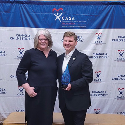 Hon. Faith Graham stands with Hilary Laughner, who is holding an award.