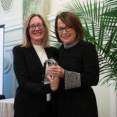 Elizabeth Clement and Hon. Loretta Rush stand together holding an award.